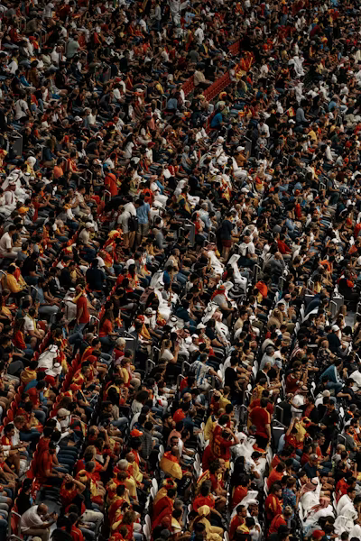 A packed crowd of football supporters cheering during a match