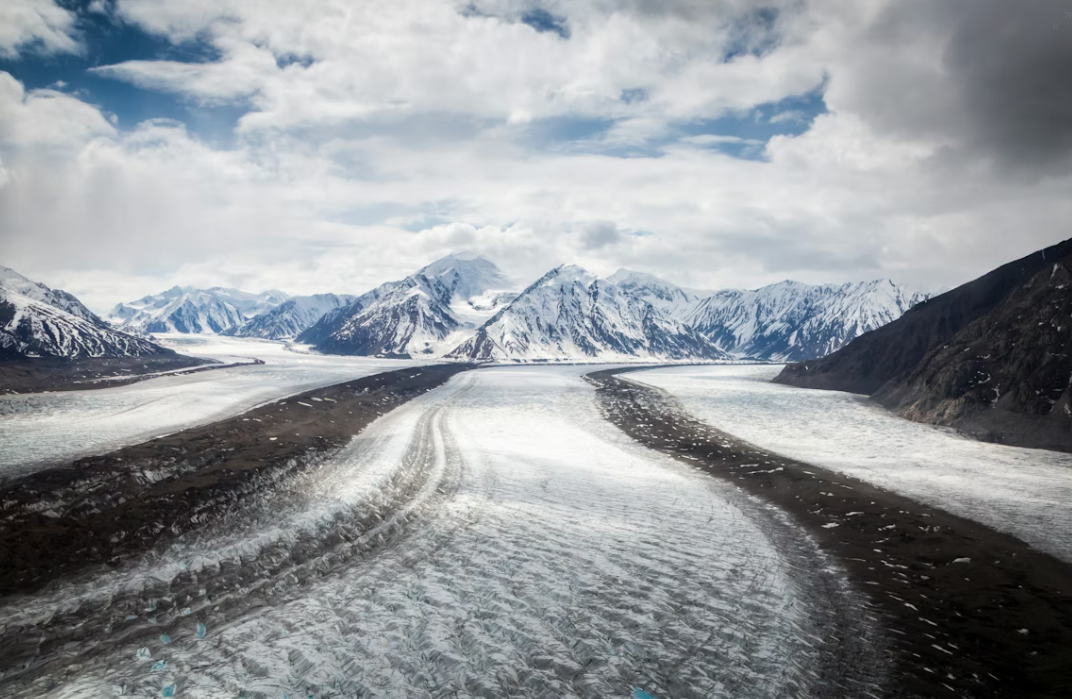 Solo competitor on foot through deep Yukon wilderness in February, headlamp in the dark